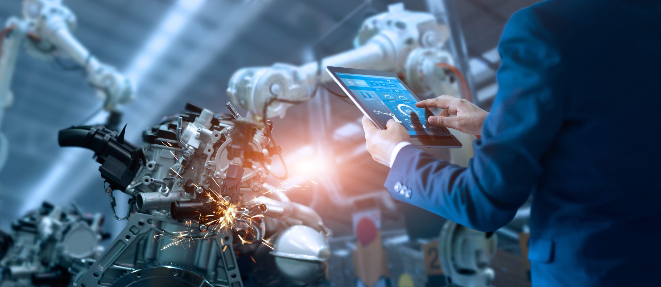 Un homme programme un robot avec une tablette