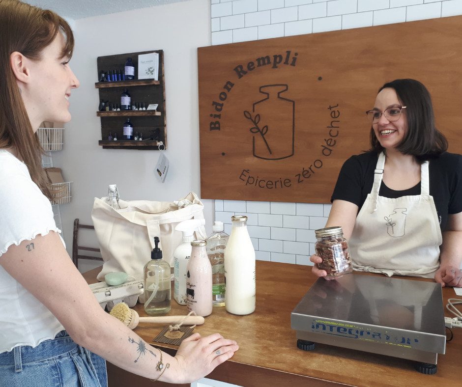 Femme derrière un comptoir d'une boutique de vrac avec une cliente