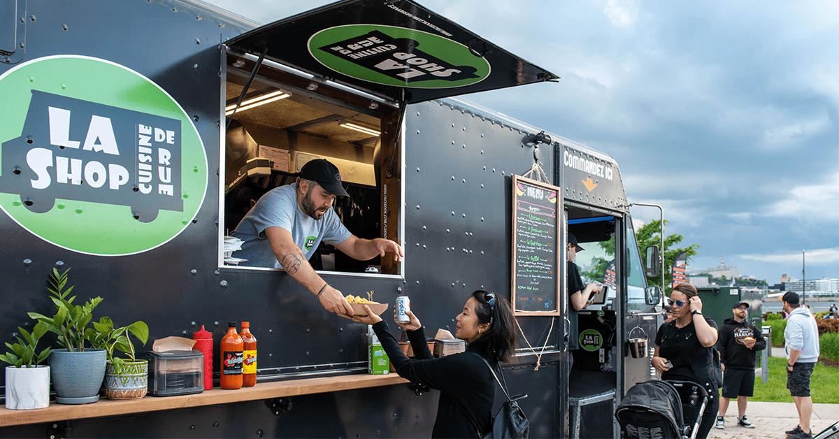 Un commerçant sert des clients depuis son camion de cuisine