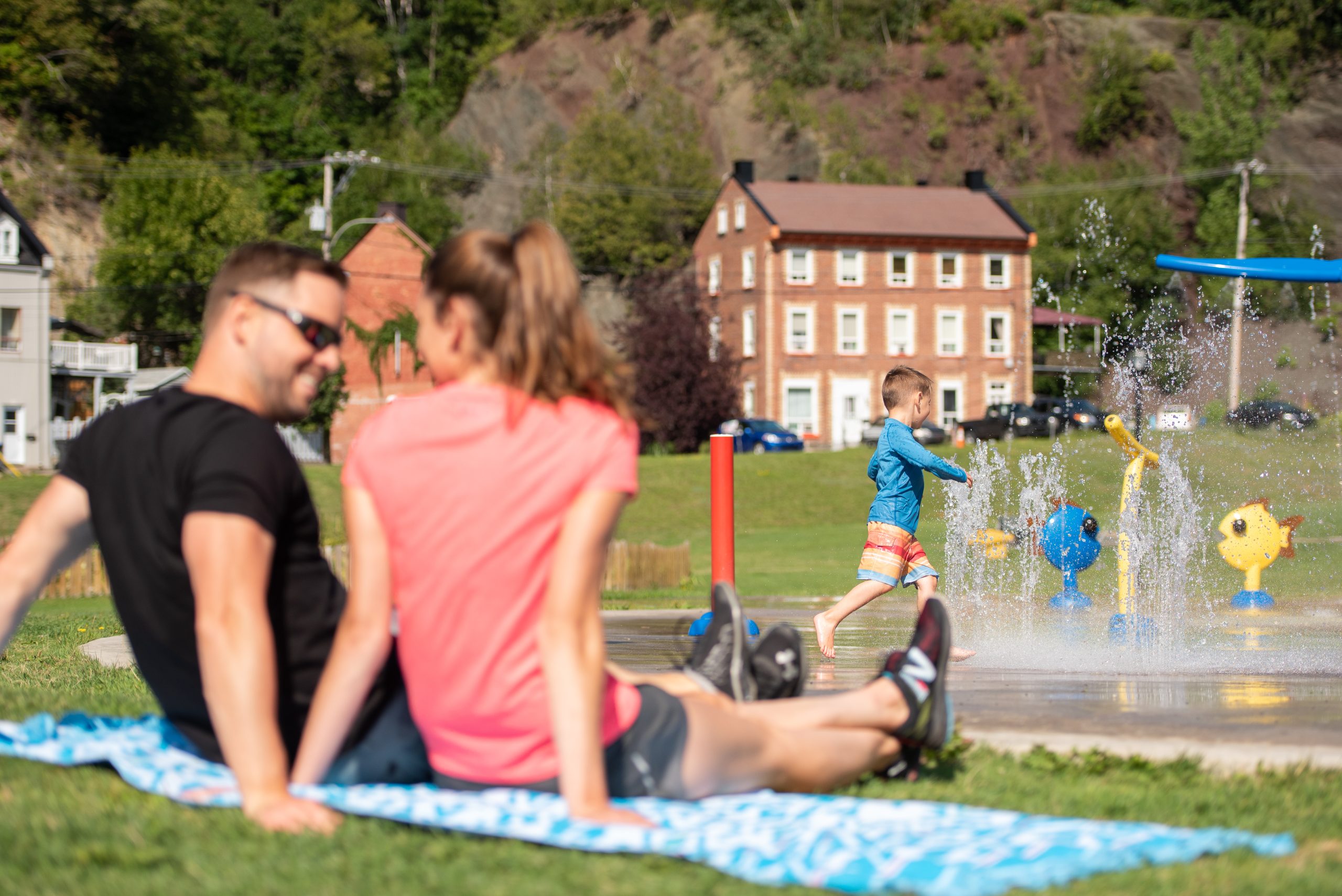 Une famille profite d'une belle journée d'été près d'un parc.